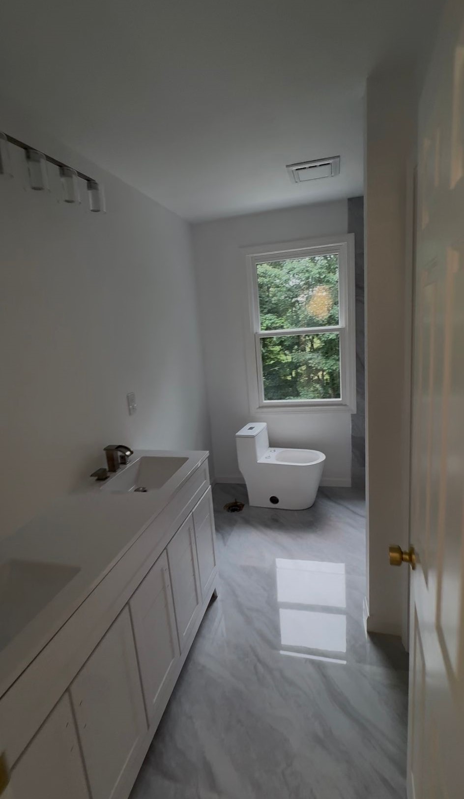Finished bathroom with freshly painted white walls, trim and vanity cabinetry