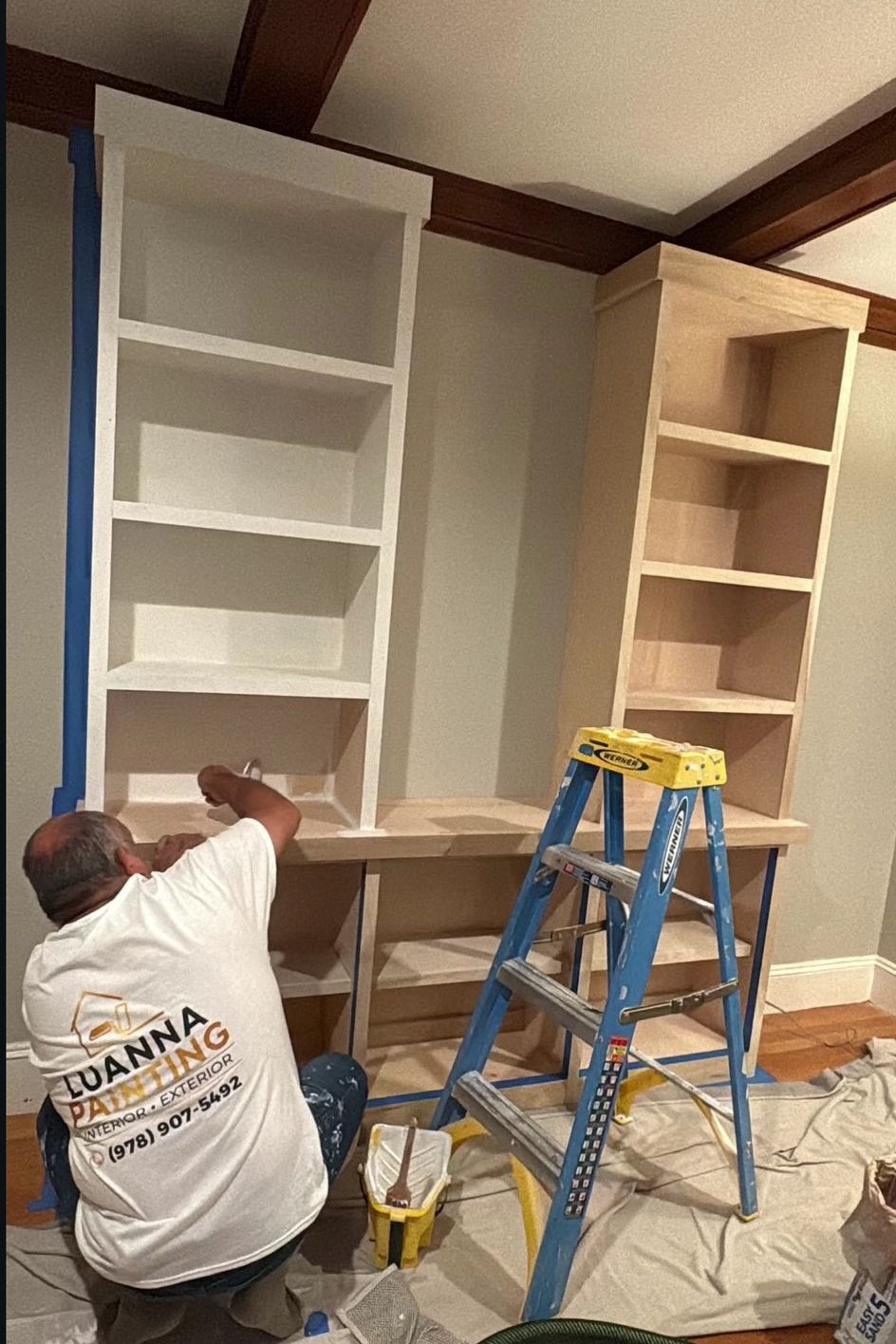 Luanna Painting crew member hand-finishing a custom built-in bookcase on site