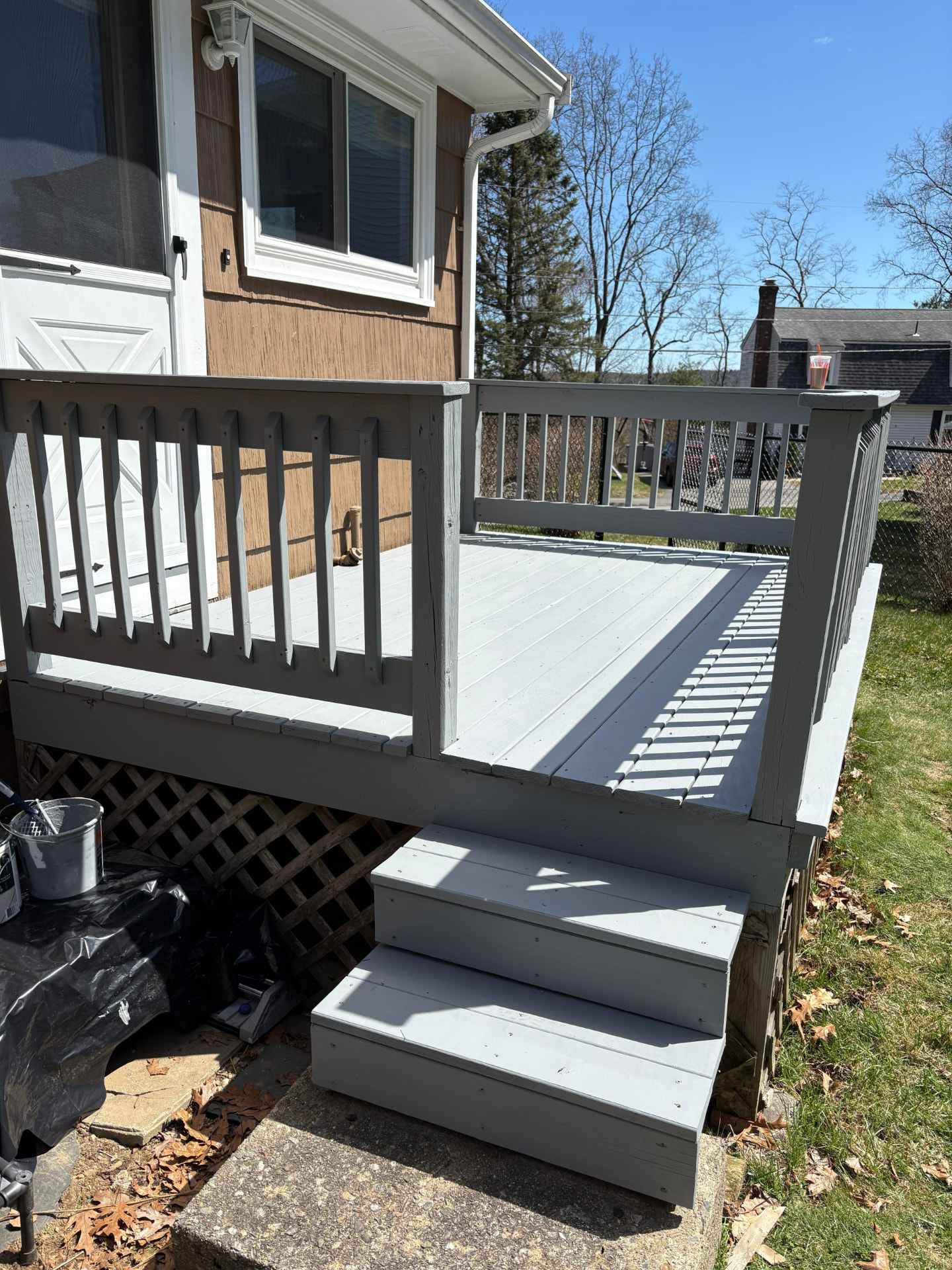 The same backyard deck after a full exterior paint and finish in soft grey