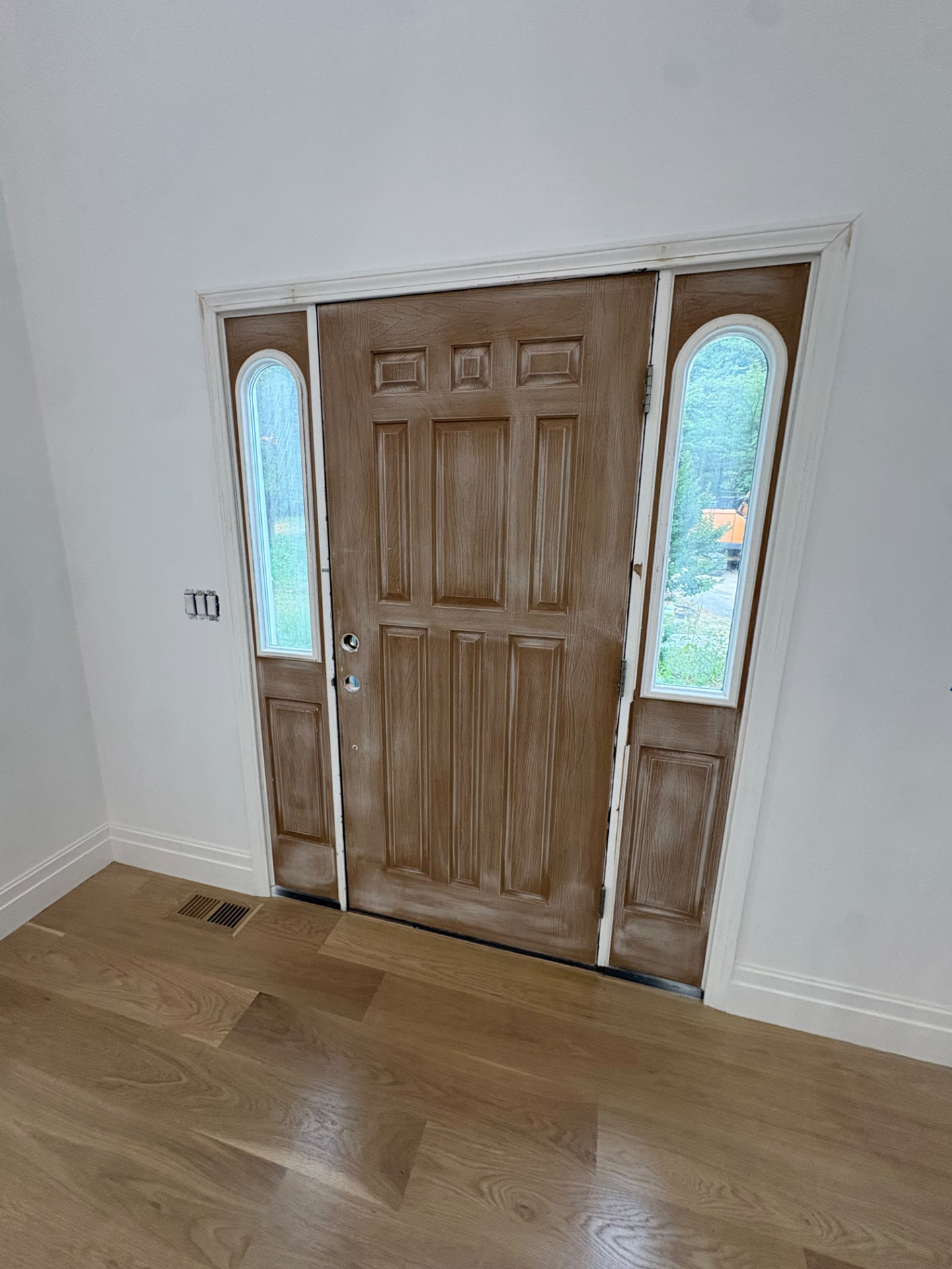Front entry door and sidelights refinished in a warm wood tone