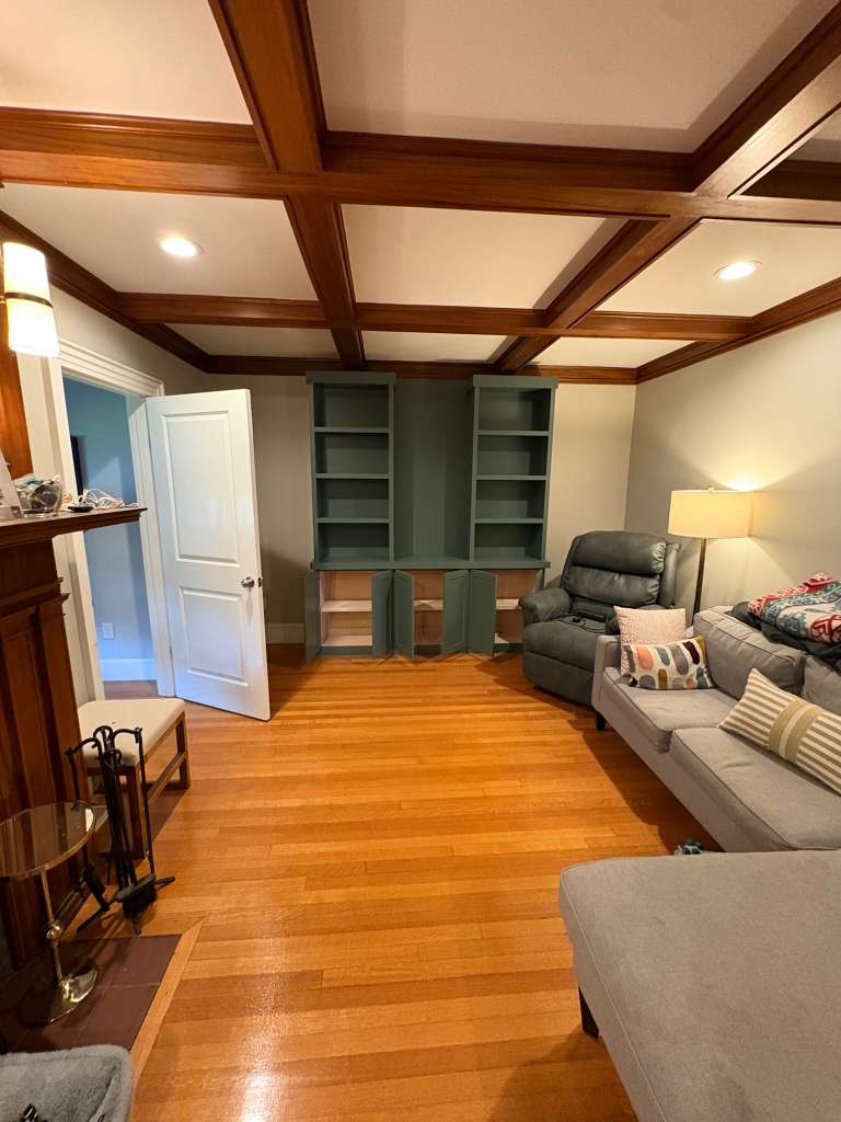 Living room with coffered wood ceiling and the newly painted green built-in shelving