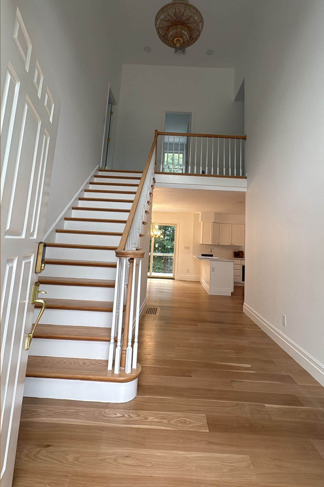 Two-story entry and staircase finished in white with natural wood treads