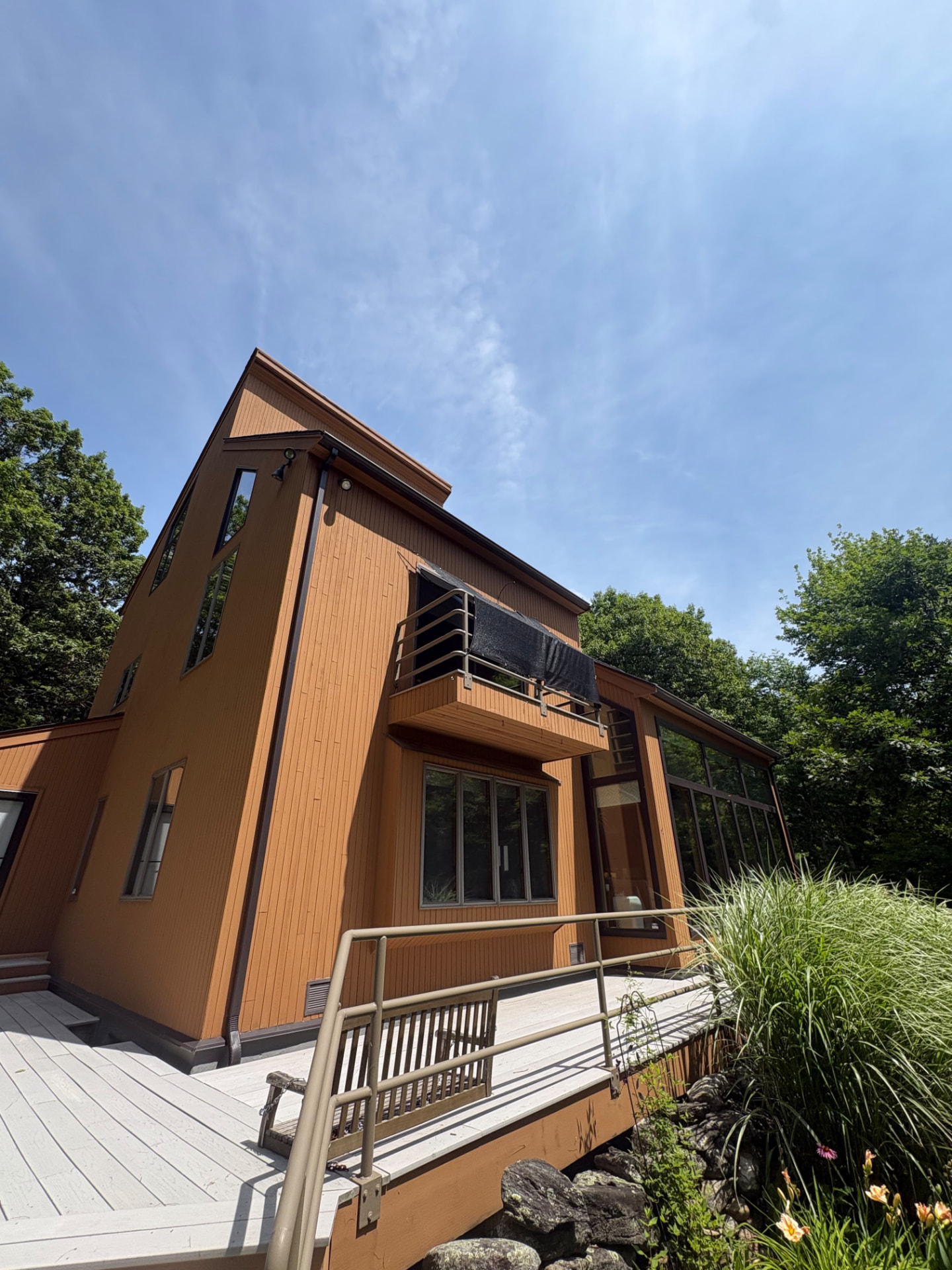 Contemporary home with freshly finished cedar-toned exterior siding and deck